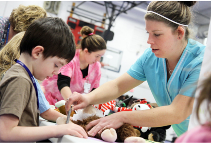 A Sandburg nursing student doctoring a teddy bear