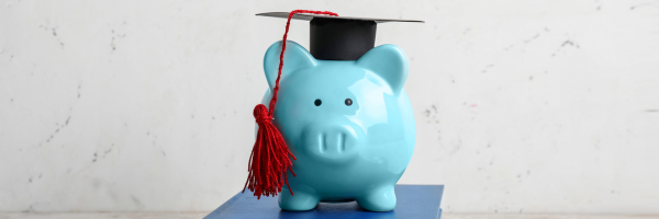 a piggy bank with a grad cap on standing on books