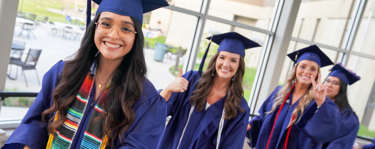 women on their cap and gowns ready for graduation.