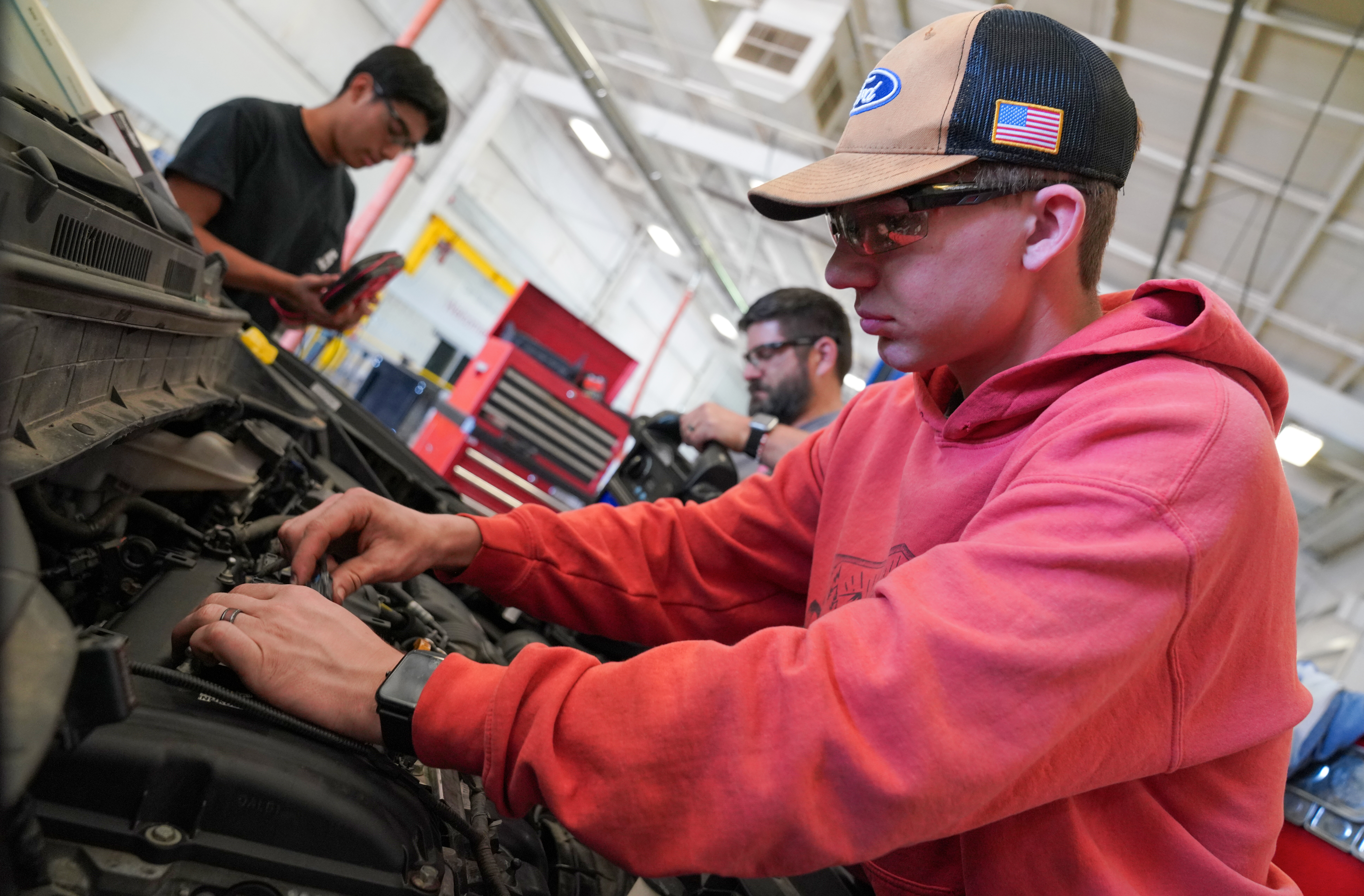 Student standing next to tool box in auto bay.