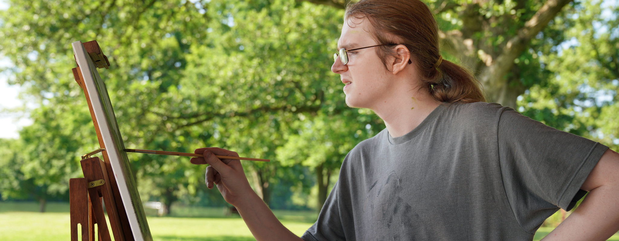 student painting  on canvas in the park.