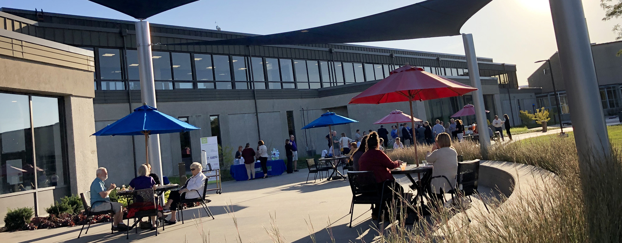 campus patio with people sitting at benches.