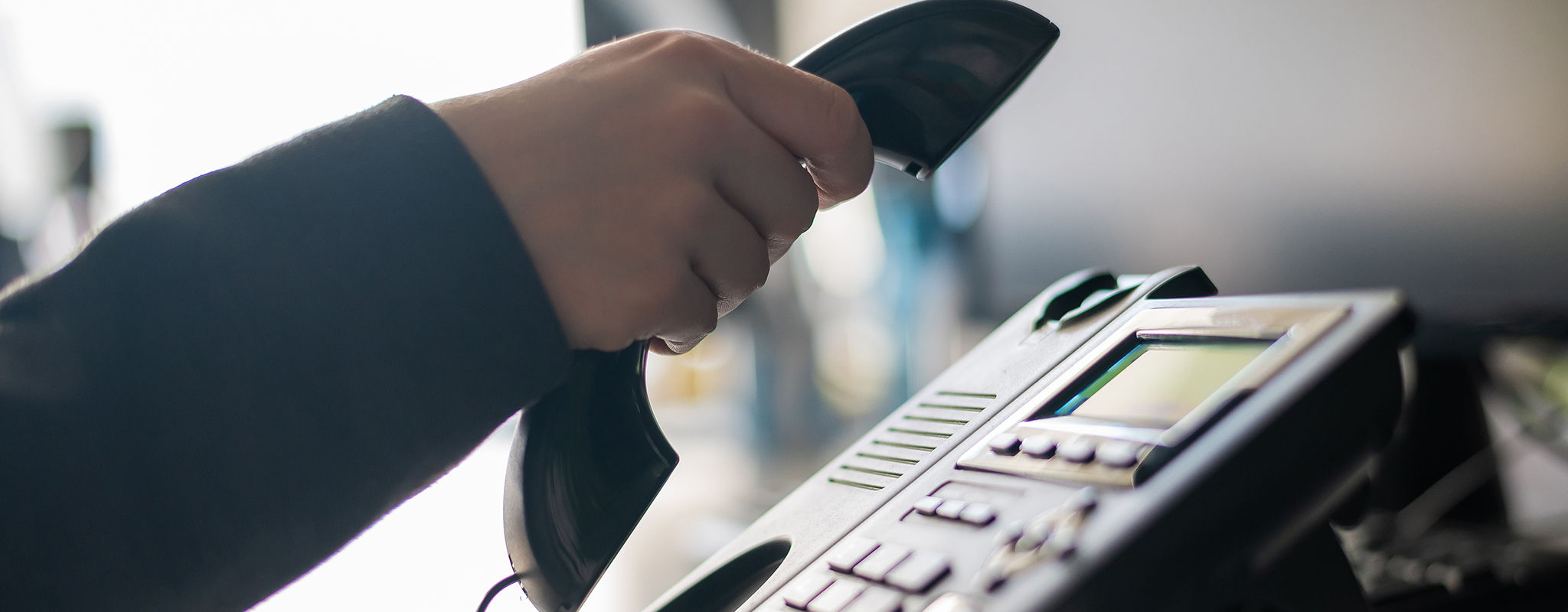 women hanging up a phone in an office setting.