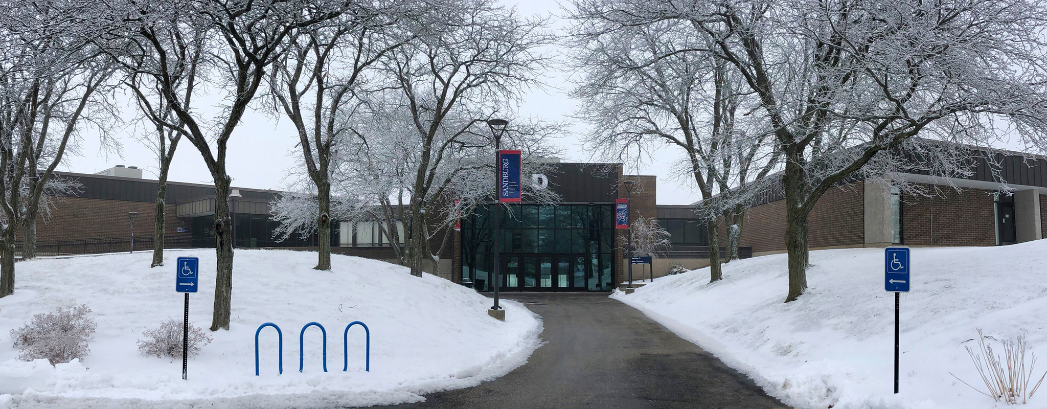 A view of building d with snow covering the ground.