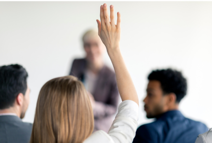 Students in a classroom with hands raised