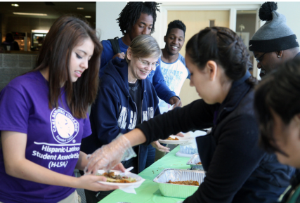 a group of people serving and receiving food at a Sandburg event